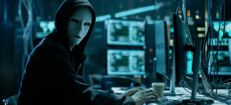 Computer hacker with a face mask and hoodie