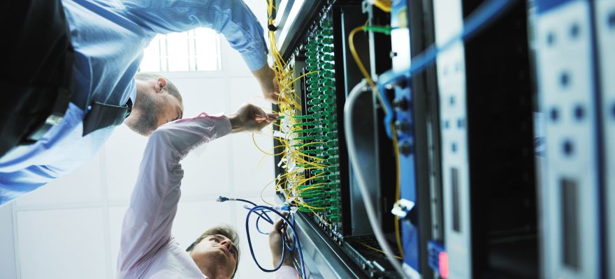 Men working on a network server rack